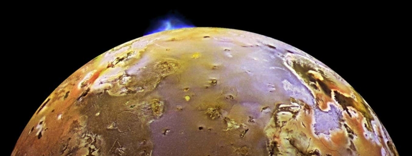 Synchronised volcanic eruptions on Io hint at a spongy interior